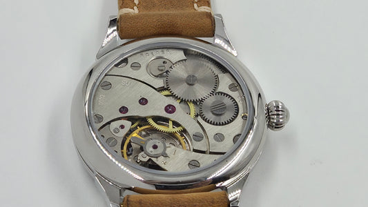 Herrenuhr mit Glasboden und Sicht auf das mechanische Uhrwerk.